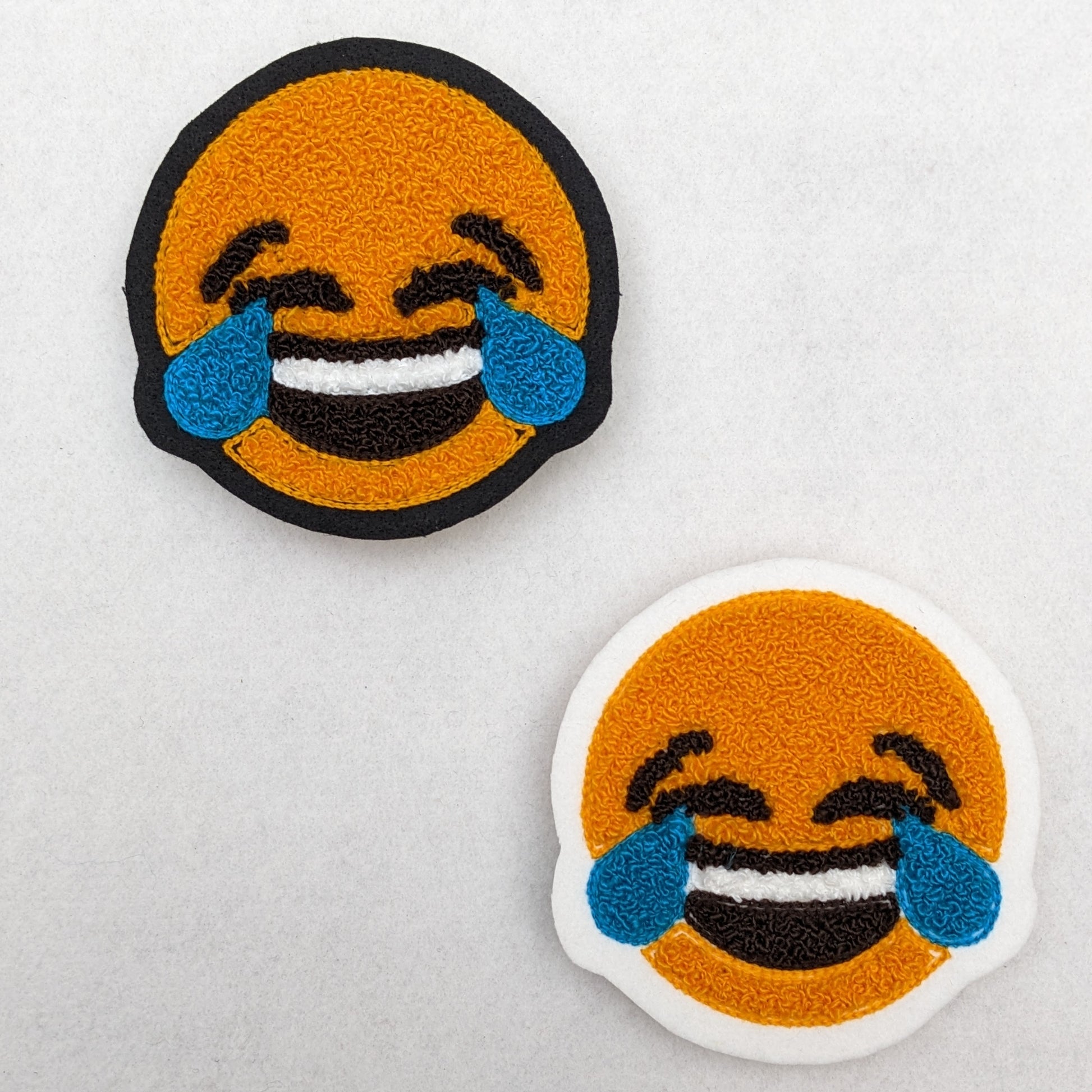Chenille patch of tears and laughing emoji.